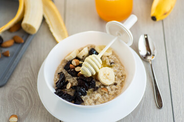 Healthy oatmeal with banana, nuts and prunes