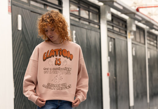 A woman with red hair wears a cozy jumper while looking down. . PSD ready to customize with your design