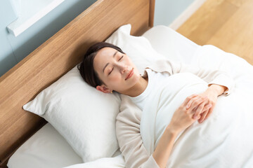 ベッドで寝る女性