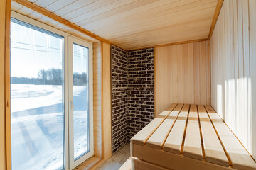 This beautifully crafted wooden sauna features a robust brick wall along with elegantly designed sliding glass doors, which greatly enhance its overall aesthetic appeal and functionality