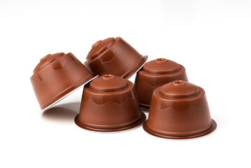 Brown coffee capsules on a white background. Plastic espresso pods for coffee machines. Isolated shot for product presentation and advertising.