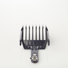 A close-up of a hair clipper attachment featuring multiple guard lengths for accurate haircuts, set against a plain background