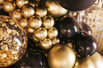 Decorative birthday photo wall. Gold and black balloons texture. Shiny balloon backdrop for New Year's Eve celebrations and photo shoots. Glittering ornament.	