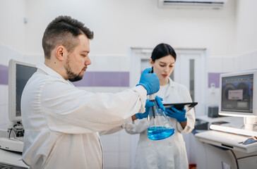 Fototapeta premium Research scientists work in a laboratory with modern equipment. Analyzes samples and genetic material using special machines in a modern laboratory. Concept of scientific research.