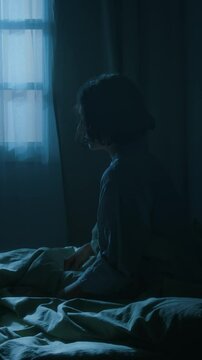Vertical shot of young woman waking up and standing up from bed, sleepwalking with arms in front of her at night