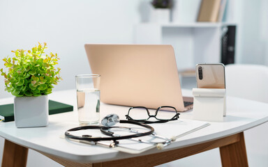 Telemedicine. Close up stethoscope, laptop, smartphone on table in doctor's office. Doctor online