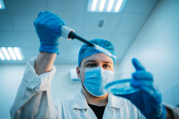 A specialist in a laboratory holds a liquid and analyzes it. The concept: utilizing high-tech methods for accurate analysis and scientific research.