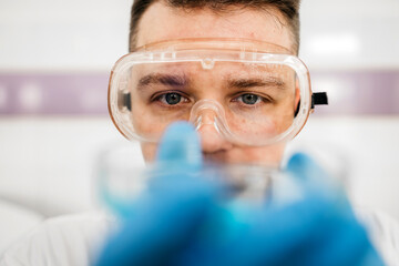 A specialist in a laboratory holds a liquid and analyzes it. The concept: utilizing high-tech methods for accurate analysis and scientific research.