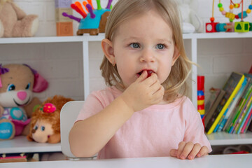Little girl eating jelly candies or vitamins. Kid.