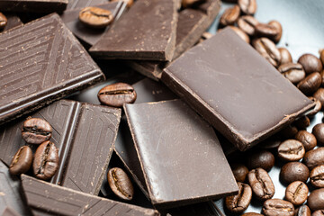 Dark chocolate pieces with coffee beans close-up.