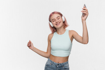 Positive stylish young girl female student wearing denim crop top standing isolated over white...