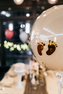 Decor for a gender reveal party in a restaurant with flowers, balloons and cake. Oh baby party