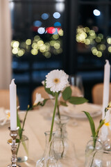 Decorated table with fresh flowers and serving with cake. Celebrating a party in a restaurant