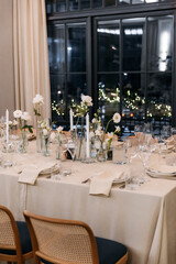 Decorated table with fresh flowers and serving with cake. Celebrating a party in a restaurant