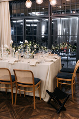 Decorated table with fresh flowers and serving with cake. Celebrating a party in a restaurant