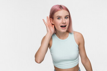 Young curious nosy fun smiling hipster woman 20s wearing casual basic crop top try to hear you...