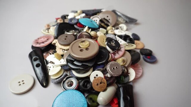 Scattered buttons &mdash; creativity and hands.
A video in which colorful buttons fall out of a transparent bag onto a table.