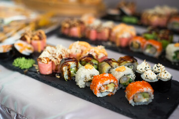 Close up view of assorted sushi - japanese sushi food. Maki and rolls with tuna, salmon, shrimp, crab and avocado.