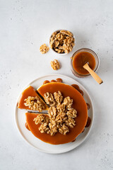 Caramel new york cake with walnut on white table