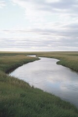 Fototapeta premium Serene landscape with winding river surrounded by lush green gra