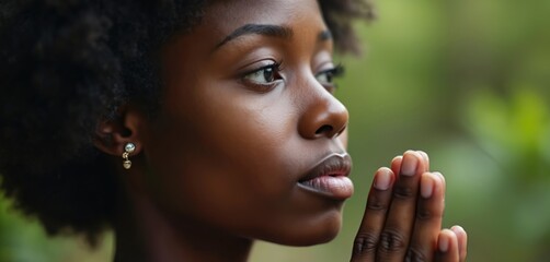 Pensive African woman folded hands in prayer. Thoughtful female seeking help with hope. Afro girl prays asking forgiveness. Christian person worshiping God. Emotional spiritual expression, faith,