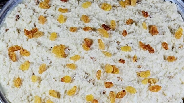 Basbosa tray with raisins or basbusa to be baked in the oven, Basbusa is a middle eastern dessert that is usually baked in Ramadan month, Arabian sweet cuisine background, selective focus
