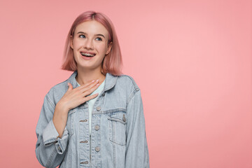 Impressed girl holding hands on heart grateful express gratitude keeps hands on chest isolated