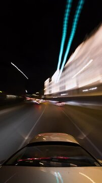 Vertical hyperlapse of a car driving in the city of Vienna at night with long exposure effect, light trails and motion