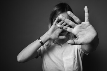 black and white photo, young woman in white t-shirt covering face with hands, emotion stress,...