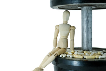 Sitting wooden manikin. Pile of dietary supplement capsules on the metal dumbbell surface....