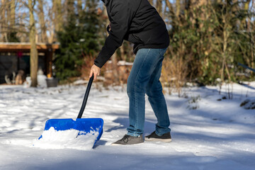 Schnee zur Sicherheit mit einem Schneeschieber  räumen