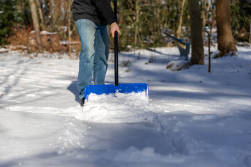 Schnee zur Sicherheit mit einem Schneeschieber  räumen