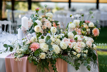 Elegant floral arrangements enhance the romantic atmosphere at a beautiful outdoor wedding reception in a sunny garden setting