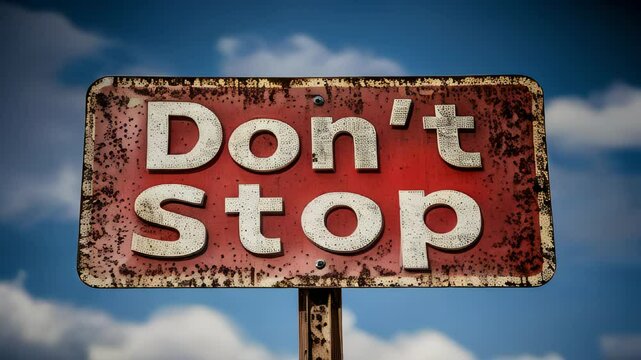 Rusty road sign urging travelers not to stop against a dramatic sky backdrop