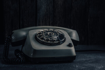 Old phone on wood background with filter effect retro vintage style and soft focus.