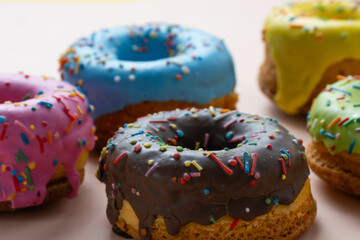 Colorful donuts with sprinkles on white background.