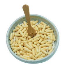 Bowl of dietary supplement capsules. Wooden fork. Nutrition, supplement dependency, holistic fitness.