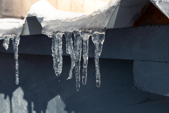 Small melting icicles hang from the roof of the building