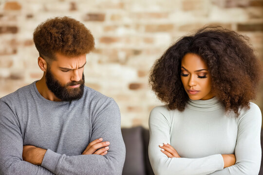 A couple sitting in their living room with arms crossed, looking away from each other in frustration, reflecting tension and relationship conflict - Powered by Adobe