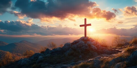 Obraz premium Sunrise illuminates a wooden cross atop a rocky mountain landscape with rolling hills in the background