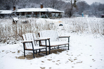 Winter landscape with benches in a fishing village on the seashore - selective focus