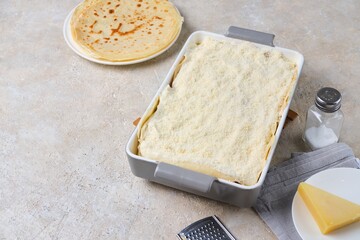Step-by-step preparation of pancake lasagna or casserole with pancakes and minced meat on a light concrete background.
