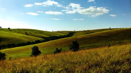 Fototapeta premium Rolling green hills under a bright blue sky peace