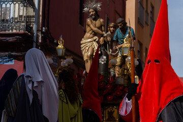 Holy Week procession passing through the streets of the city, the penitents march solemnly with their faces covered by high hoods, leaving only their eyes visible