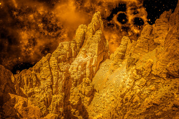 Alien golden landscape, with surface of another planet with rocks and sky full of nebula and stars. Photo montage that recreates an alien landscape of an extraterrestrial planet