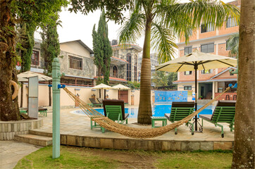 Hammock hanging by a pool side with no people around