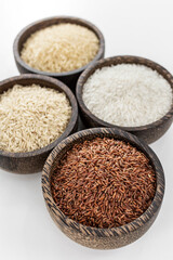 different kinds of asian rice grains in bowls on white background