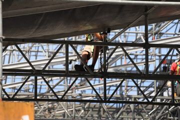 Worker assembling metal structures with safety measures