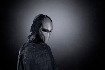 Mysterious humanoid alien at night over dark misty background