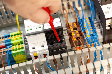 Electrician working on electrical panel wiring
